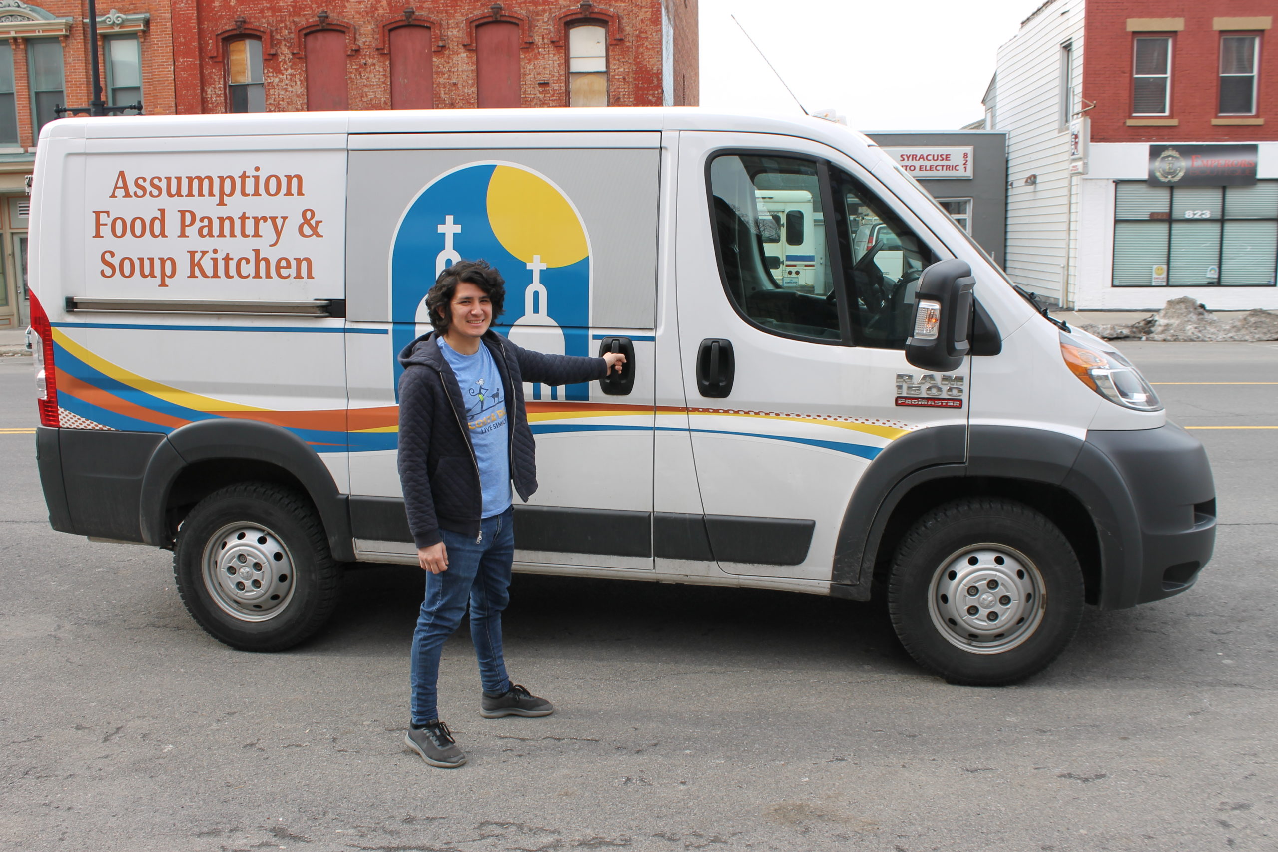 Elias in front of the Assumption Food Pantry and Soup Kitchen van